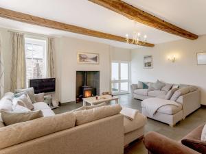 a living room with two couches and a fireplace at 8 bed in Cockermouth 82453 in Bridekirk