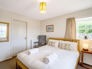 um quarto com uma grande cama branca com toalhas em 8 bed in Cockermouth 82453 em Bridekirk