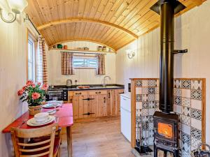 a kitchen with a wood stove and a table with chairs at 1 Bed in Ironbridge 80727 in Leighton