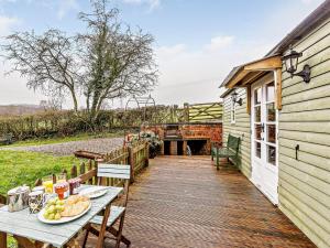 a wooden deck with a table and a building at 1 Bed in Ironbridge 80727 in Leighton