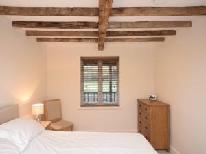 a bedroom with a bed and a dresser and a window at 1 bed in Sherborne 80736 in Wootton Glanville