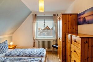 Un dormitorio con dos camas y una ventana. en Ferienhaus Diekster - Obergeschoss, en Norddeich