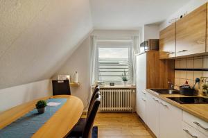 Una pequeña cocina con una mesa y una ventana. en Ferienhaus Diekster - Obergeschoss, en Norddeich