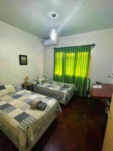 1 dormitorio con 2 camas y cortina verde en Departamento peatonal Mendoza en Mendoza