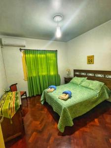 a bedroom with a green bed with two towels on it at Departamento peatonal Mendoza in Mendoza