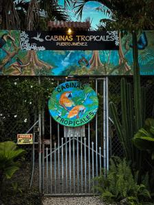 a gate with a sign in front of a park at Cabinas Tropicales in Puerto Jiménez
