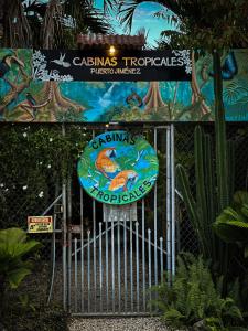 ein Tor mit einem Schild vor einem Park in der Unterkunft Cabinas Tropicales in Puerto Jiménez