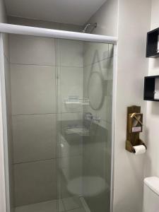 um chuveiro com uma porta de vidro na casa de banho em Resort, Piscina e Natureza em SP em São Paulo