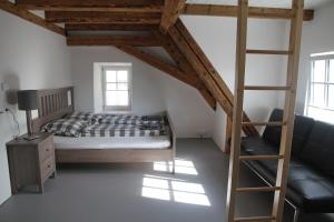 a bedroom with a bed and a ladder and a couch at Villa Arena in Geisingen