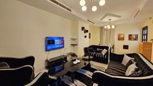 a living room with two couches and a flat screen tv at Perfect Vacation with 3bhk villa in Dubai