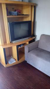Pousada AME في كاكسياس دو سول: غرفة معيشة مع أريكة وتلفزيون بشاشة مسطحة
