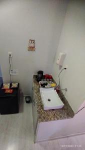een badkamer met een wastafel op een granieten aanrecht bij Apartamento central particular in Lavras