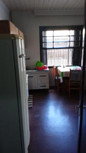 a kitchen with a refrigerator and a table in it at Pousada AME in Caxias do Sul