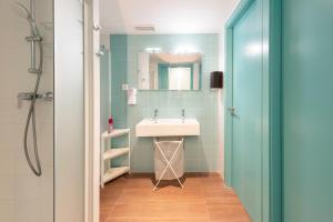 y baño con lavabo y espejo. en Hostelle - Women only hostel Barcelona, en Barcelona