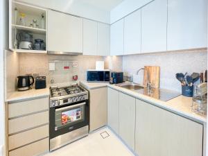 a kitchen with white cabinets and a stove top oven at Beautiful apartment by Dubai Mall 161BR-2 in Dubai