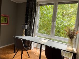 une table et des chaises devant une grande fenêtre dans l'établissement Apt Prinz Friedrich - Zentral - Zimmerprinzen, à Oldenbourg