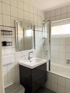 y baño blanco con lavabo y ducha. en Apartment Prinz Friedrich - Zentral - Designer Wohnung, en Oldenburg