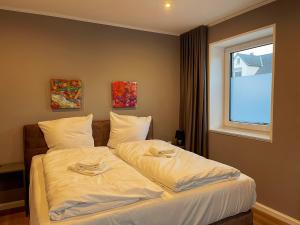 Schlafzimmer mit einem Bett mit weißer Bettwäsche und einem Fenster in der Unterkunft Apartment Prinzessin Aphrodite - inkl Disney - Zimmerprinzen in Oldenburg