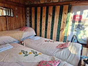 a room with two twin beds and a window at Sentidos Cardinales in Perito Moreno