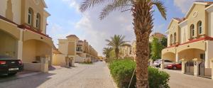 una palma accanto a una strada con case di Perfect Vacation with 3bhk villa a Dubai