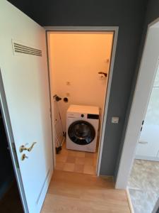 a laundry room with a washing machine in a hallway at Apartment Prinz Ernst August - Zentral - Zimmerprinzen in Oldenburg