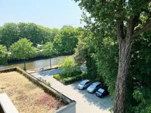 zwei Autos auf einem Parkplatz neben einem Baum geparkt in der Unterkunft Apt Prinz Ernst August - Zimmerprinzen - Zentral in Oldenburg