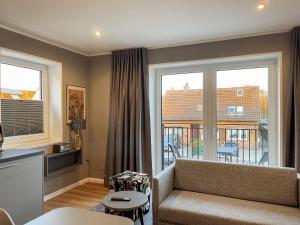 ein Wohnzimmer mit Couch und großem Fenster in der Unterkunft Apartment Prinzessin Eloise - Zimmerprinzen in Oldenburg