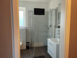 ein Badezimmer mit Glasdusche und Waschbecken in der Unterkunft Apartment Prinzessin Eloise - Zimmerprinzen in Oldenburg