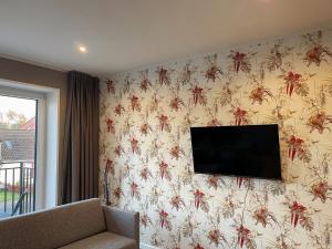 ein Wohnzimmer mit einem TV an der Wand in der Unterkunft Apartment Prinzessin Eloise - Zimmerprinzen in Oldenburg