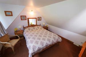 a bedroom with a bed and a chair in a attic at The Lodge in Lochgilphead