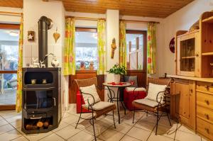 a kitchen with a stove and chairs and a table at Schwarzwald Nescht Triberg in Triberg