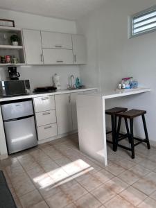 a white kitchen with a counter and a table at Studio21-A Centric Comfort Apartment in Bayamon