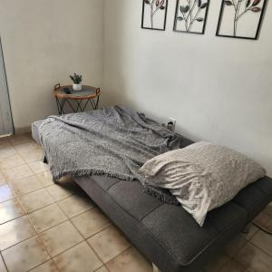 a bed sitting in a room with a table at Studio21-A Centric Comfort Apartment in Bayamon