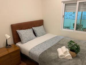 a bedroom with a bed with towels and a window at Apartamento familiar 3 habitaciones Alcala in Madrid