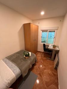 um quarto com uma cama, uma secretária e uma janela em Apartamento familiar 3 habitaciones Alcala em Madri