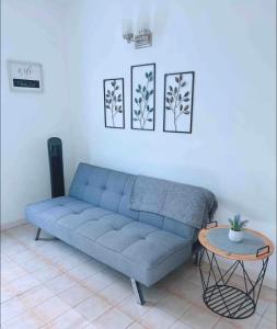 a blue couch in a living room with a table at Studio21-A Centric Comfort Apartment in Bayamon