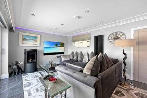 uma sala de estar com um sofá e uma lareira em Little Fox Lodge Hideaway Glencoe - 5 Star with Hot Tub overlooking Loch Linnhe em Glencoe