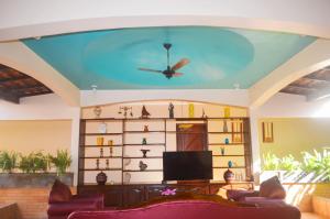 a living room with a ceiling with a ceiling fan at Pers Palace Hotel in Santa Inês