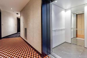 een hal met een geruite vloer in een gebouw bij Appartement neuf, lumineux & cosy proche La Défense, Neuilly & Paris in Puteaux