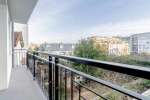 een balkon met uitzicht op de stad bij Appartement neuf, lumineux & cosy proche La Défense, Neuilly & Paris in Puteaux