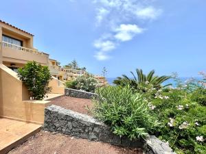 - une vue sur une maison ornée de plantes et de fleurs dans l'établissement Estandar un dormitorio con estupenda vista y piscina, Playa Los Roques, à Los Realejos