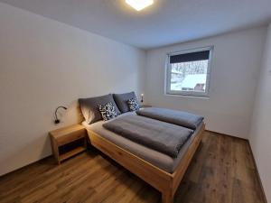 Schlafzimmer mit einem Bett und einem Fenster in der Unterkunft Apart Madeleine in Sankt Leonhard im Pitztal