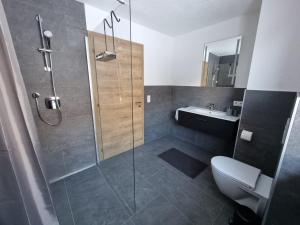 Un baño con ducha, inodoro y lavabo. en Apart Madeleine, en Sankt Leonhard im Pitztal 30 fotos más