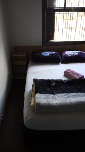 a bedroom with two beds and a window at Pousada AME in Caxias do Sul