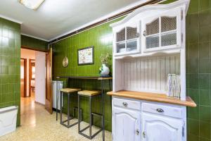 ein Badezimmer mit grünen Wänden und einem weißen Schrank in der Unterkunft Apartament el Llac in Puigcerdà