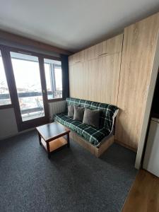 a living room with a couch and a coffee table at Studio 942-Particulier-Résidence L'Ours Blanc-Alpe d'Huez-Centre Station in L'Alpe-d'Huez