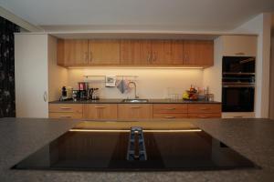a kitchen with wooden cabinets and a counter top at Astergut Boutique Apartment in Saalbach Hinterglemm +6 photos