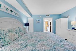 a bedroom with a large bed with blue walls at Bay Watch Resort 1203 - Perfect Oceanside Getaway in Myrtle Beach