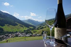 a wine glass sitting on a table with a bottle of wine at Astergut Boutique Apartment in Saalbach Hinterglemm