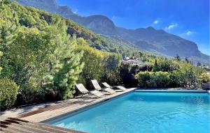 ein Swimmingpool mit Stühlen und Bergen im Hintergrund in der Unterkunft La Maison Du Bonheur in Veyrier-du-Lac